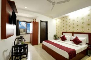 Hotel King Plaza Near Delhi Airport في نيودلهي: غرفه فندقيه بسرير وكرسي