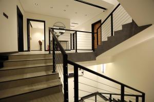 una escalera en una casa con barandillas negras en STeam Residence102#, en Riad
