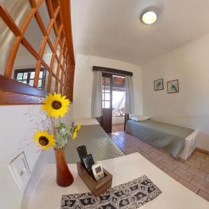 uma sala de estar com um vaso de flores sobre uma mesa em Hotel Natur Campeche em Florianópolis