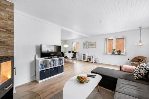 a living room with a couch and a table at Nyd den skønne natur ved hav og fjord in Thyborøn