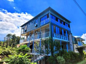 - un bâtiment bleu avec des balcons sur le côté dans l'établissement GUEST HOUSE NONA, à Chakvi