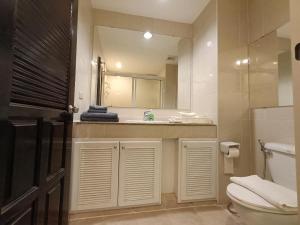uma casa de banho com um WC, um lavatório e um espelho. em View Talay 6 Pattaya Beach Apartment by Honey em Pattaya Central