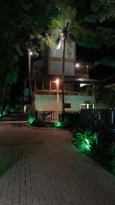 a building with a tree and lights in front of it at Hotel Natur Campeche in Florianópolis