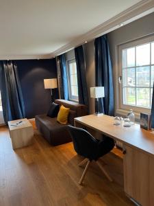 a living room with a desk and a couch at Hotel Lamm in Baiersbronn