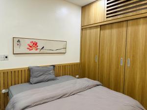 a bedroom with a bed and a wooden cabinet at Diep's House in Hanoi