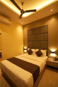 a bedroom with a large bed and two lamps at HOTEL BOSTON in Mumbai