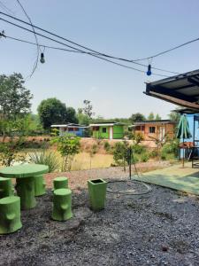 un groupe de tables de pique-nique vertes et de sièges verts dans l'établissement Vanessa Guest House, 