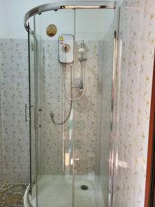 um chuveiro com uma caixa de vidro na casa de banho em Vanessa Guest House 