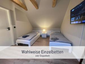 Habitación pequeña con 2 camas y TV. en moderne Kate Kiel, en Kiel