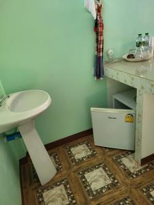 y baño con lavabo blanco y mesa. en Vanessa Guest House 