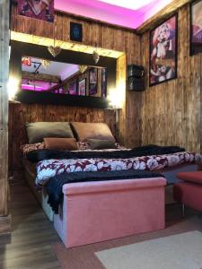 ein Schlafzimmer mit einem großen Bett in einem Zimmer mit Holzwänden in der Unterkunft Romantic Room - Superbe Appartement Studio Jardin - Proche Disneyland Paris in Crécy-la-Chapelle