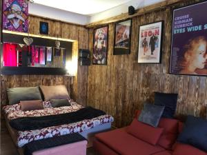 ein Schlafzimmer mit einem Bett, einem Sofa und Plakaten in der Unterkunft Romantic Room - Superbe Appartement Studio Jardin - Proche Disneyland Paris in Crécy-la-Chapelle