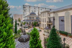 a courtyard of a building with trees and a building at Manor Luxury Hotel Baku in Baku