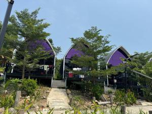 un bâtiment violet avec des arbres devant dans l'établissement Dream Resort, à Koh Rong
