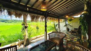 a patio with a pool and chairs and a view of a field at Villa Sare - House with panorama rice field view in Yogyakarta