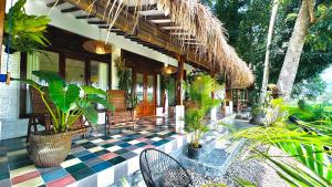 a porch of a house with a checkered floor at Villa Sare - House with panorama rice field view in Yogyakarta
