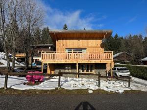 a wooden house with a deck in the snow at Chalet de 4 chambres avec jardin et wifi a La Lechere a 1 km des pistes in La Léchère