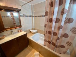 a bathroom with a tub and a shower curtain at Spacious & Modern New Apartment in Heraklio Town +14 photos