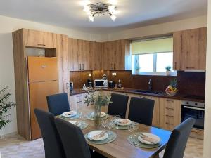 a kitchen with a wooden table with chairs and a dining room at Spacious & Modern New Apartment in Heraklio Town