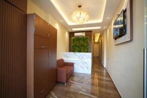 un couloir avec un canapé et un lustre dans l'établissement HOTEL BOSTON, à Mumbai