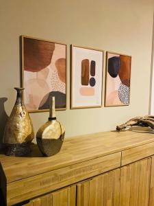 un estante con jarrones y cuadros en una pared en Sun&Sea Apartment en Lido di Ostia