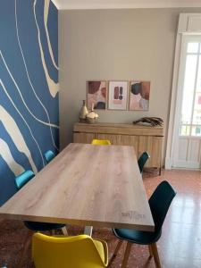 una mesa de madera y sillas en una habitación en Sun&Sea Apartment en Lido di Ostia