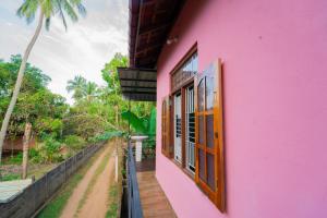 a pink house with a view of a street at Passi CK Homestay in Pasikuda