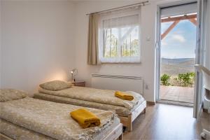 a bedroom with two beds and a window with a view at InSpiral Peaceful Retreats in Kismaros