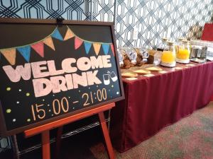 un cartel de bebida de bienvenida en una mesa con un cartel de bebida de bienvenida en Hotel Rosso Karuizawa, en Karuizawa