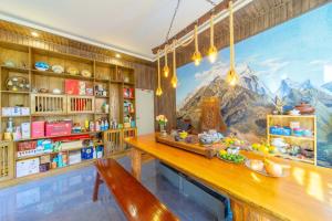 uma sala de jantar com um grande mural de uma montanha em Gegewu Inn - Lijiang Ancient Town em Lijiang
