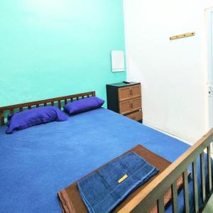 um quarto com uma cama com almofadas roxas e uma cómoda em Rumah Teman Homestay em Semarang