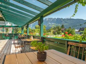 a deck with tables and chairs and a blue roof at Hotel Kogler in Bad Mitterndorf