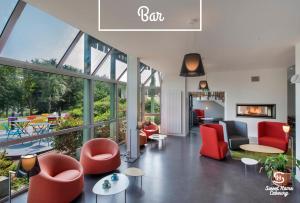 uma sala de estar com cadeiras vermelhas e uma lareira em Sweet Home Cabourg Hôtel et gîtes em Cabourg