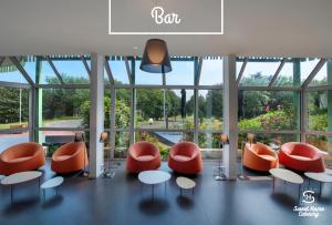 a lobby with orange and white chairs and a large window at Sweet Home Cabourg Hôtel et gîtes in Cabourg +21 photos