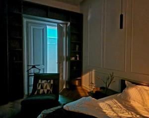 a bedroom with a bed and a chair and a window at Victory Apartment in Timişoara
