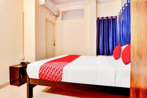 a bedroom with a bed with red and blue curtains at Hotel O IRA Comforts in Bengaluru