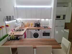 a kitchen with white cabinets and a table with chairs at Aglaya 2 - Pomorie Bay in Pomorie