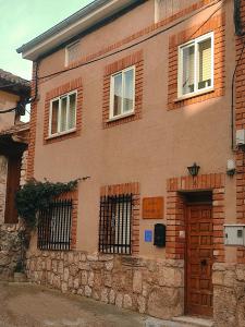 un edificio de ladrillo con ventanas y una puerta en Casa Daniela, en Fuentidueña