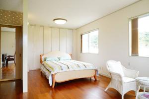 a bedroom with a bed and a table and chairs at 【駐車場4台！】都会の喧騒から離れ大自然に囲まれた豪邸～大石林山への観光にも最適～ in Kunigami