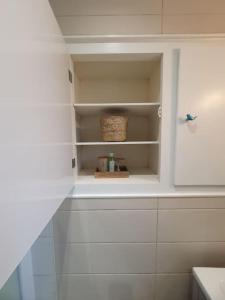 a white cabinet with a basket in a bathroom at Gîte Thera Cottage 3 étoiles in Le Vieux-Bourg