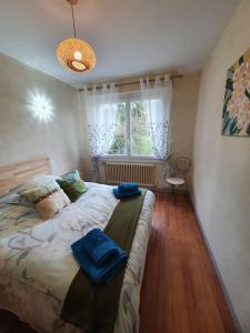 a bedroom with a bed with blue towels on it at Gîte Thera Cottage 3 étoiles in Le Vieux-Bourg