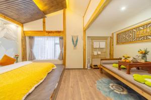 丽江GeGeHouse - Lijiang Old Town的一间卧室配有一张黄色的床和一张桌子