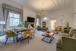 sala de estar con sofá, mesas y sillas en Harley Street Spectacular Suites with High Ceilings, High Luxury, en Londres