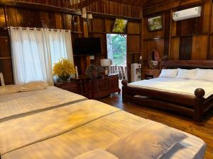a bedroom with two beds and a television in it at Paradise on the Tree in Cat Tien