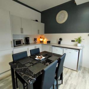 a kitchen with a table with chairs and a plate on the wall at The Old Smiddy Cottage and Apartment in Balloch