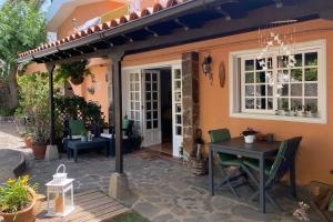a patio with a table and a house at Vivienda vacacional el grillo feliz in Tegueste