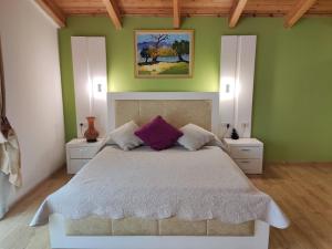 een slaapkamer met een groot bed met paarse kussens bij Hotel & Restaurant White City in Berat