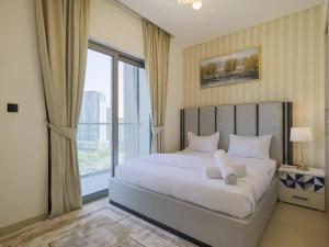 a bedroom with a white bed with a large window at Budget Staying - Comfortably and Luxuriously in Dubai in Dubai
