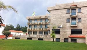 a building with a statue on top of it at Hotel Pedramar in A Lanzada