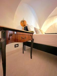 een slaapkamer met een bed en een houten bureau bij May's Apartment in Catania